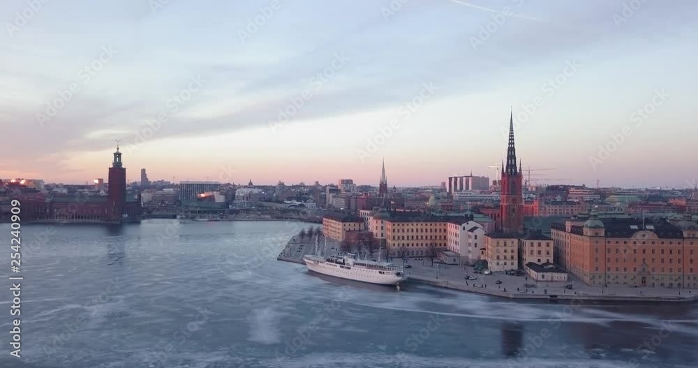 Beautiful sunset winter aerial view Stockholm Sweden. Magnificent cold Swedish golden hour evening. Frozen urban cityscape, historical Riddarholmen church. 4K drone footage. Beautiful sunset winter aerial view Stockholm Sweden. Magnificent cold Swedish golden hour evening. Frozen urban cityscape, historical Riddarholmen church. 4K drone footage.