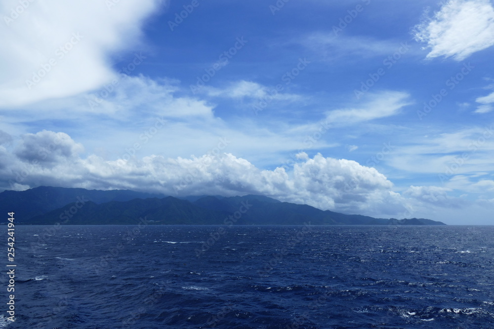 Island of Yakushima covered in clouds and seen from a ship