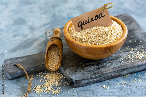 Raw white quinoa in a wooden bowl.