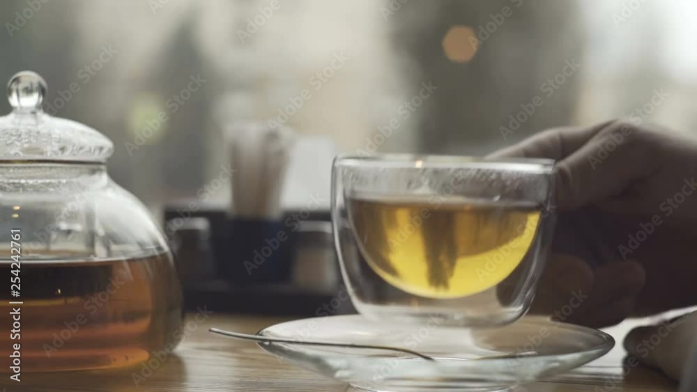 Teapot and cu with green tea on a table in cafe