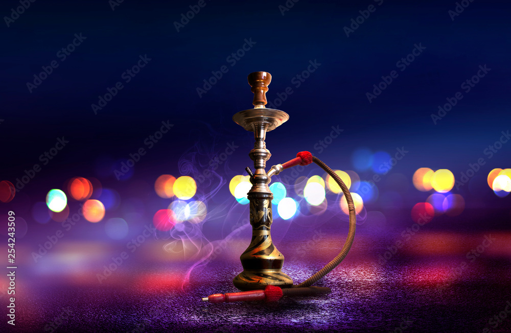 Hookah with smoke on the background of an empty scene, wet asphalt and colored neon light, blurry lights of the night city, bokeh Hookah with smoke on the background of an empty scene, wet asphalt and colored neon light, blurry lights of the night city, bokeh