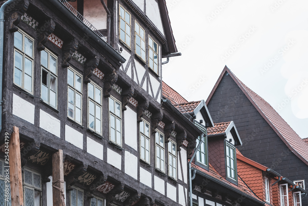 facade of an old half-timbered house with carvings, windows and red tiles