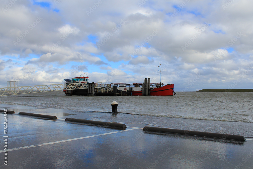 a red boat is moored with high flood with spring tide in winter in holland