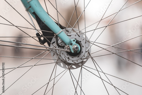 close up of the front wheel with spikes and part of the bike fork of turquoise bike