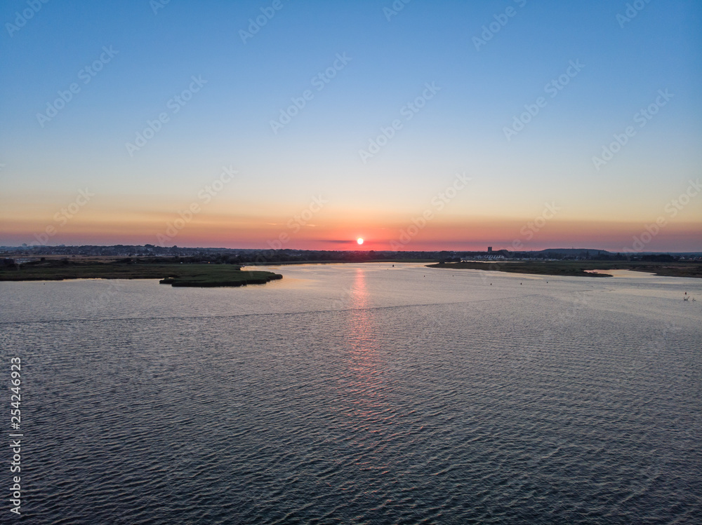 An aerial view of a sunset over the water of an harbor at blue hour