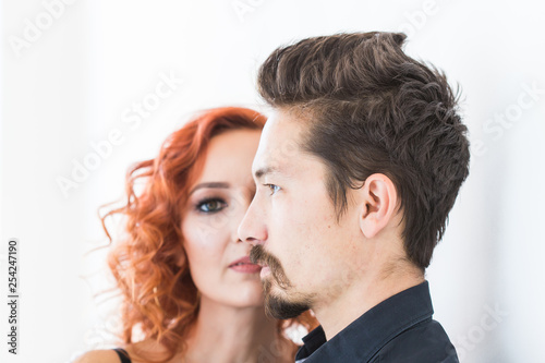 People and beauty concept - Head shot portrait of couple with serious faces over white wall