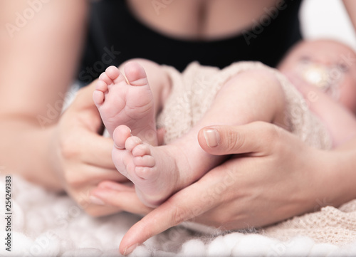 Kleine Füße eines Babys in den Händen der Mutter