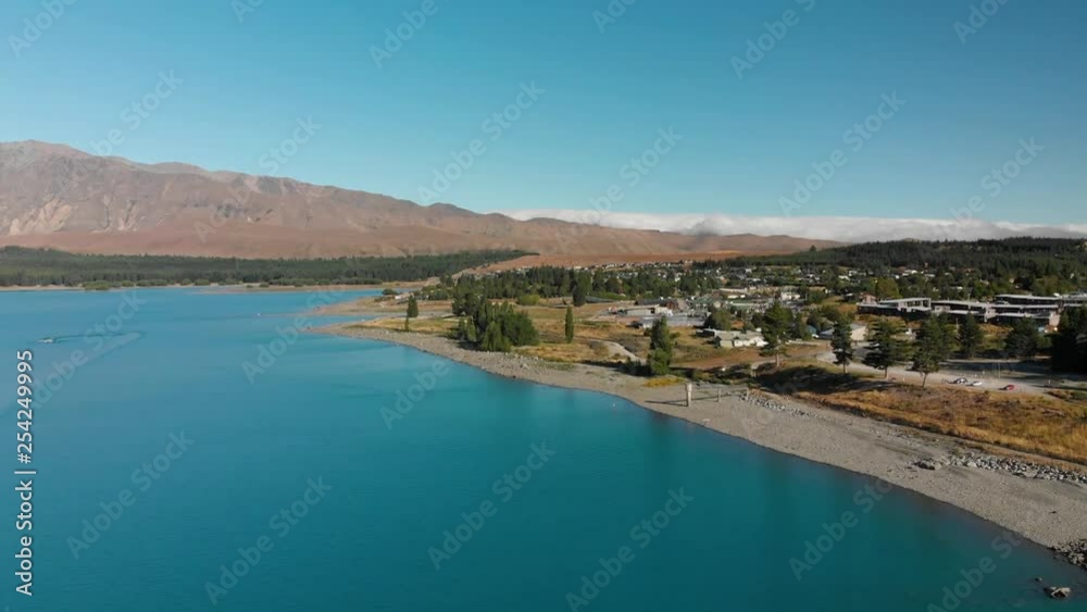 SLOWMO - Aerial shot of Lake Tekapo, New Zealand and its Beautiful Turquoise Blue Water wiht mountains in background SLOWMO - Aerial shot of Lake Tekapo, New Zealand and its Beautiful Turquoise Blue Water wiht mountains in background