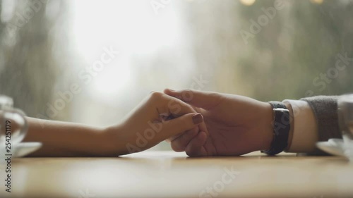 Young couple holding hands at the cafe