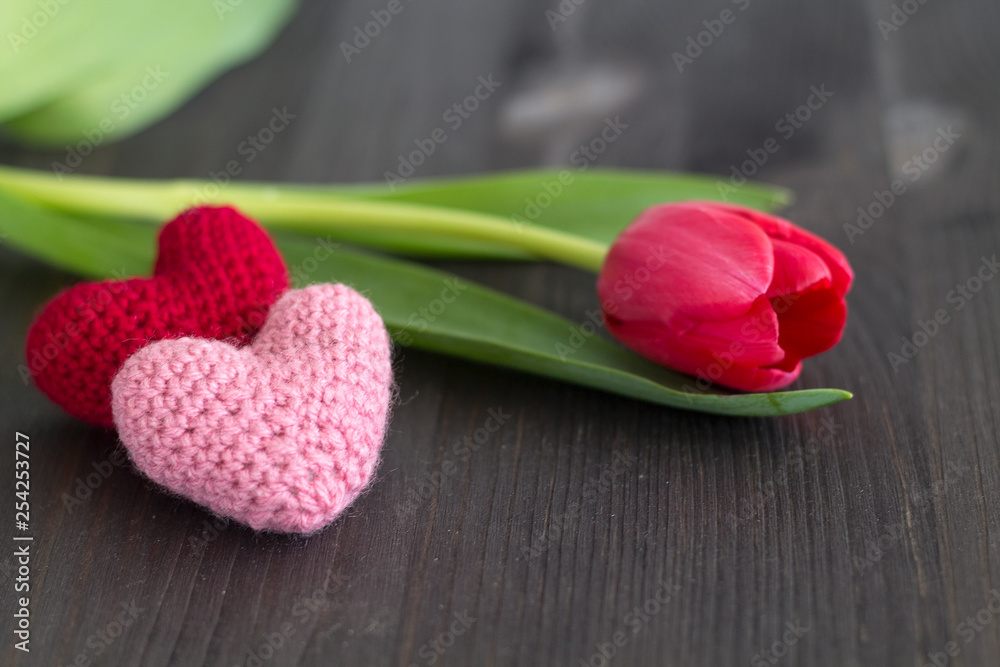 Two hearts on black background with red tulips. Two hearts on black background with red tulips.