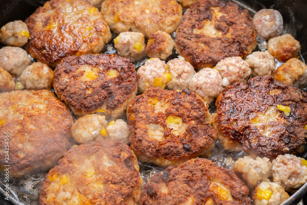 Meatballs different sizes on the cooking pan