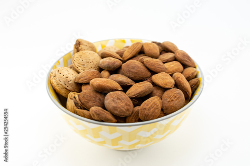 Group of almonds in a bowl on white background