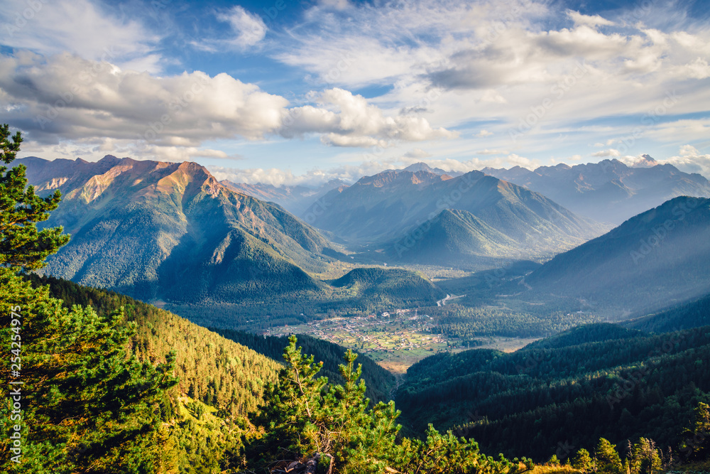 Beautiful view of the mountainous area at sunset with clouds. Small village in a mountain valley. Arkhyz, Caucasus Beautiful view of the mountainous area at sunset with clouds. Small village in a mountain valley. Arkhyz, Caucasus