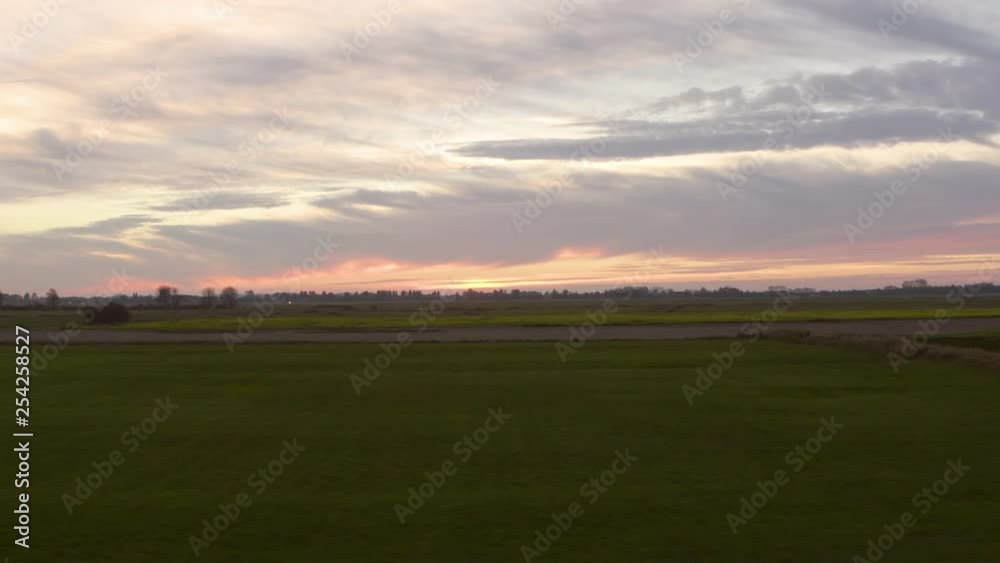 Rural agriculture area, during sunset, south west of the Netherlands. Dynamic aerial shots. Flying backwards, revealing trees. Rural agriculture area, during sunset, south west of the Netherlands. Dynamic aerial shots. Flying backwards, revealing trees.