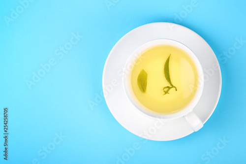White cup of green oolong tea over blue © breakingthewalls