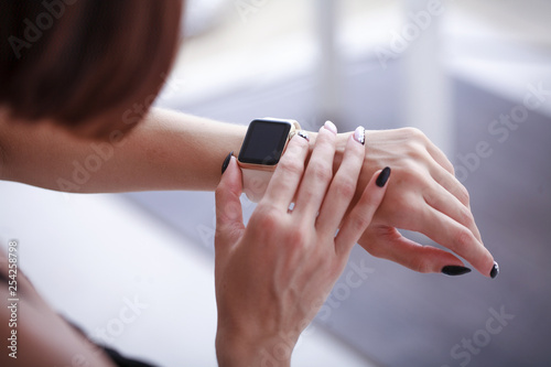 using her smartwatch at home in the living room