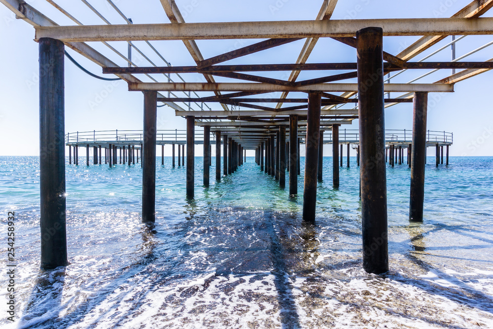view of the sea under the metal pier