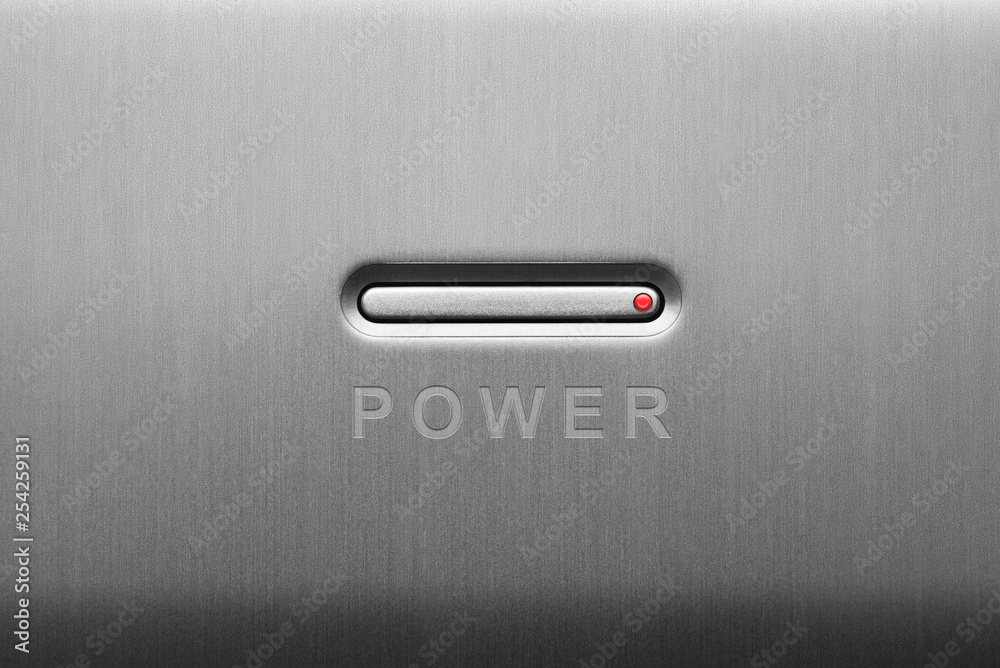 The power button on the aluminum panel. Close-up. The power button on the aluminum panel. Close-up.