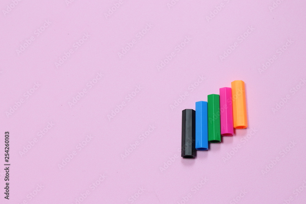 Five colorful pen cap on a pink millennial background. Space to insert the text. Office stuff. Minimalism. Metaphor to teamwork and hierarchy Five colorful pen cap on a pink millennial background. Space to insert the text. Office stuff. Minimalism. Metaphor to teamwork and hierarchy