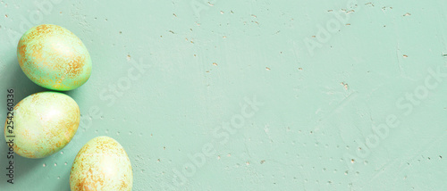 Banner with green Easter eggs with golden spots