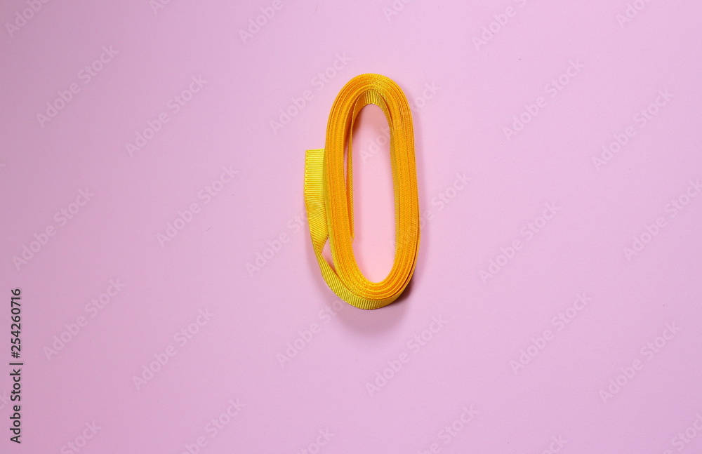 Yellow ribbon on a pink millennial background. Ribbon to sew clothes and crafts. Space to insert text