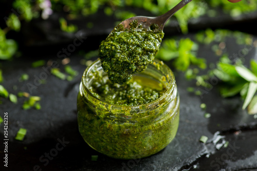 Fotografie, Obraz pesto sauce in a spoon, jar with pesto sauce