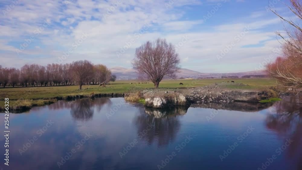drone flying forwards, over lake, reflecting trees, clouds in the background, in Kayseri, Turkey drone flying forwards, over lake, reflecting trees, clouds in the background, in Kayseri, Turkey