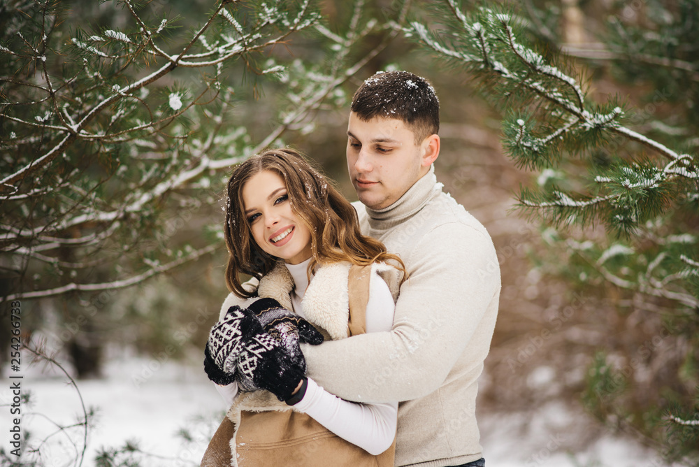 Winter love story on ice. Stylish lovers boy and girl on a snowy background . Romance Winter love story on ice. Stylish lovers boy and girl on a snowy background . Romance
