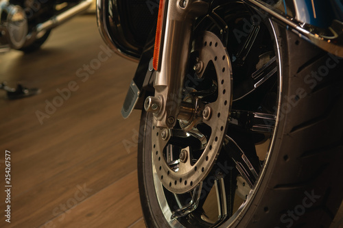 front fork of a motorcycle with a front wheel, brake disc, brake cylinder. Close up. Soft focus