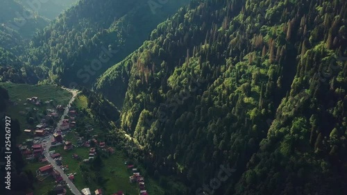 Wallpaper Mural drone dolly backward footage, revealing thin waterfall down green mountain, deserted cute village in idyllic valley, rays of sun, in Turkey Torontodigital.ca