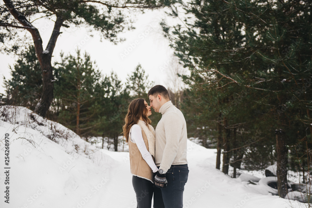 Winter love story on ice. Stylish lovers boy and girl on a snowy background . Romance Winter love story on ice. Stylish lovers boy and girl on a snowy background . Romance