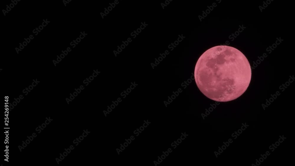 Red Moon covered by dark and translucent clouds close up Red Moon covered by dark and translucent clouds close up