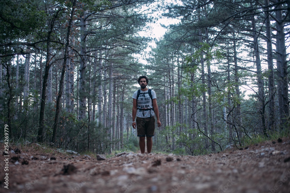 A young man with a backpack on a hiking trip in the mountains. A young man with a backpack on a hiking trip in the mountains.