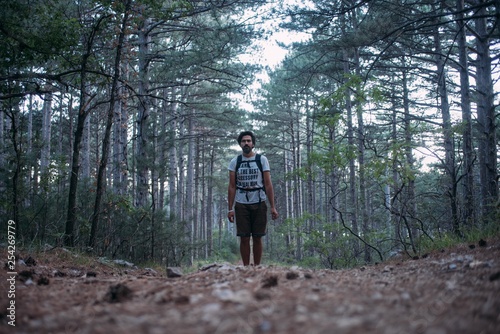 A young man with a backpack on a hiking trip in the mountains.