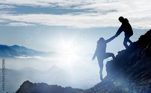 Obraz na płótnie Mountaineers help each other to reach the summit