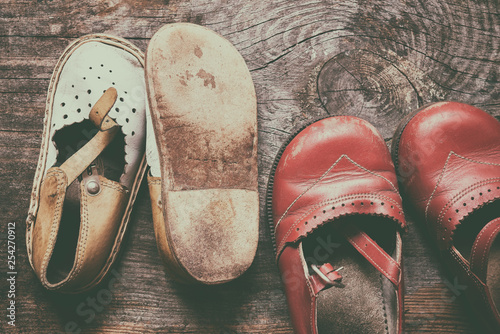 Children vintage shoes on old wood background. Childhood memory