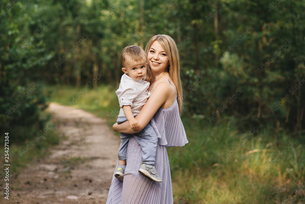 Fototapeta premium Happy young family spends time together in nature. Sweet mother with baby