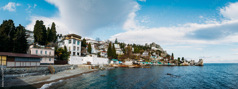 Small Crimean village on sea coast with old buildings and mountain on background, beautiful European nature landscape and seascape