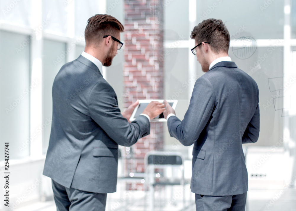 employees discuss information using a digital tablet.