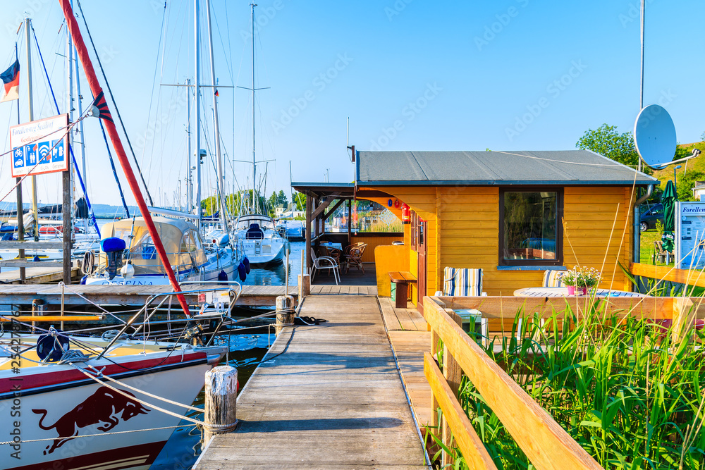 SEEDORF PORT, RUGEN ISLAND - MAY 27, 2018: Sailing boats anchoring in beautiful marina on coast of Rugen island, Baltic Sea, Germany. It is very popular tourist destination in summer season. SEEDORF PORT, RUGEN ISLAND - MAY 27, 2018: Sailing boats anchoring in beautiful marina on coast of Rugen island, Baltic Sea, Germany. It is very popular tourist destination in summer season.