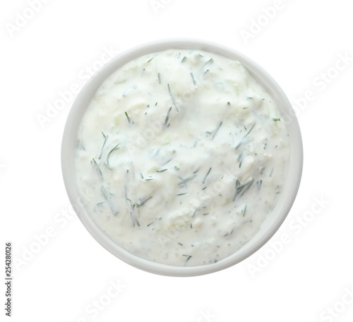 Bowl with cucumber sauce on white background, top view photo