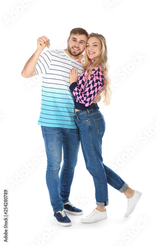 Happy young couple with house key on white background
