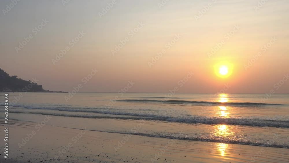Camera pans right revealing fabulous view of sun low in the sky, viewed from a tropical beach Camera pans right revealing fabulous view of sun low in the sky, viewed from a tropical beach