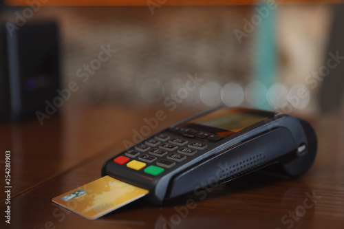 Credit card machine for non cash payment on wooden counter in cafe