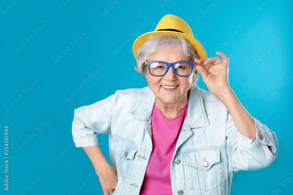 Portrait of mature woman in hipster outfit on color background Portrait of mature woman in hipster outfit on color background