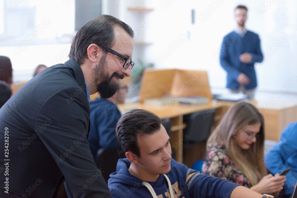 Group of students study with professor in modern school computer Group of students study with professor in modern school computer