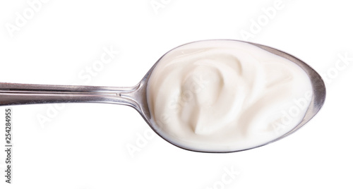 Sour cream in metal spoon isolated on white background. Top view. Flat lay