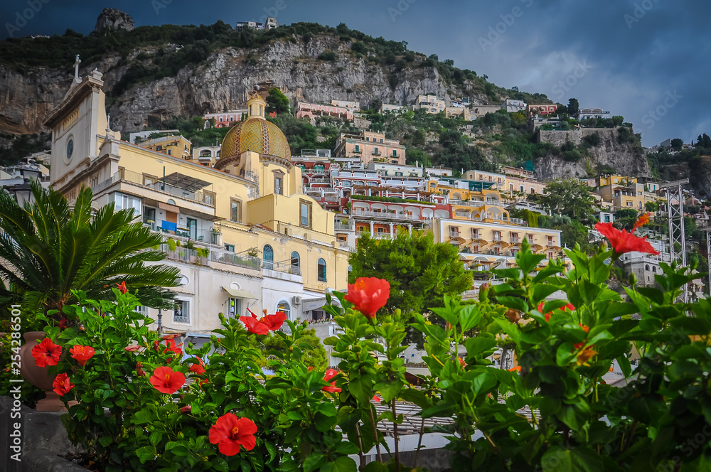 Fototapeta premium Red flowers with church background in Positano village