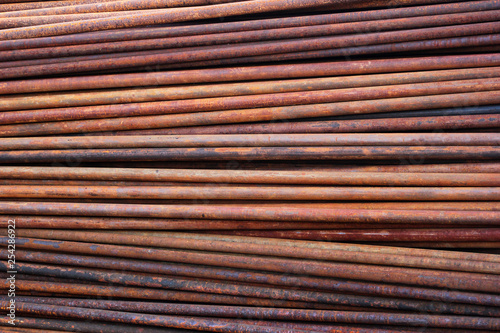 Pile of rusty metal pipes as industrial background