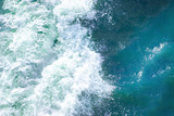 bright blue surface of ocean water with waves, spray and white foam, background, texture